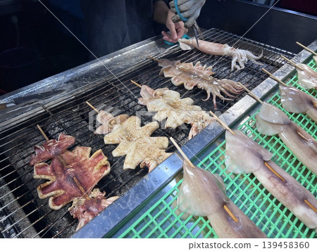 在台中的夜市拍攝攤販熟練的製作烤魷魚 在台中的夜市拍攝攤販熟練的製作烤魷魚 139458360