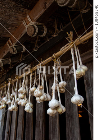 Garlic hanging from the eaves and an old house Garlic hanging from the eaves and an old house 139458540