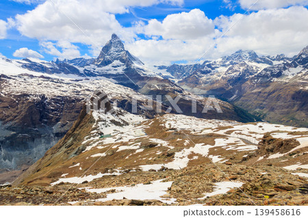 Scenic view on snowy Matterhorn mountain peak in sunny day with blue sky in Switzerland. Beautiful nature background of Swiss Alps covered with snow. Famous travel destination Scenic view on snowy Matterhorn mountain peak in sunny day with blue sky in Switzerland. Beautiful nature background of Swiss Alps covered with snow. Famous travel destination 139458616