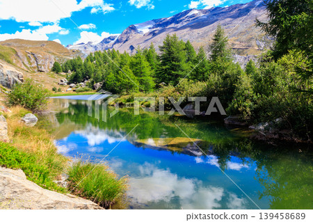View of Grindji Lake (Grindjisee) and Swiss Alps at summer on Five-lake trail in Zermatt, Switzerland View of Grindji Lake (Grindjisee) and Swiss Alps at summer on Five-lake trail in Zermatt, Switzerland 139458689