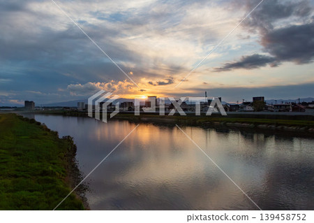 Sunset and cityscape reflected in the Kitakami River (Iwate Prefecture) 139458752