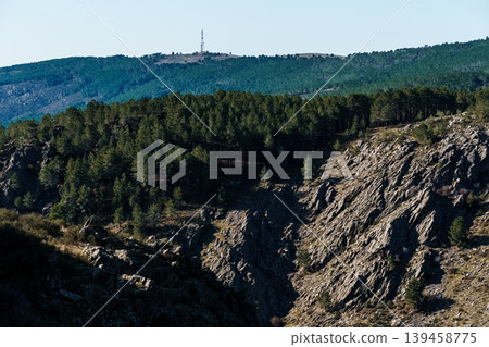 Jagged rock formation on mountainside with communication tower Jagged rock formation on mountainside with communication tower 139458775