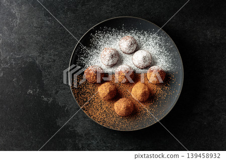 Chocolate truffles on a black plate. Chocolate truffles on a black plate. 139458932