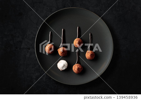 Chocolate truffles on a black plate. Chocolate truffles on a black plate. 139458936