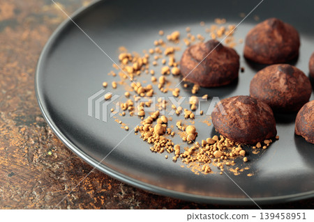 Chocolate truffles on a black plate. Chocolate truffles on a black plate. 139458951