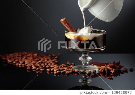 Cream is poured into a glass with coffee liquor and ice. Cream is poured into a glass with coffee liquor and ice. 139458973