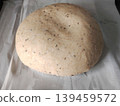 Raw sourdough bread dough with caraway seeds resting on white parchment paper before baking. 139459572