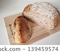 Sliced homemade artisan sourdough bread on a wooden cutting board on a white background. 139459574