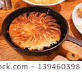 香噴噴的圓形餃子，趁熱盛在煎鍋裡，外皮金黃酥脆。 139460398