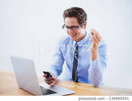 Headphones, business and man with a smartphone, laptop and listening to music in a workplace. Person, employee and consultant with a cellphone, sound and streaming audio with radio, podcast and smile Headphones, business and man with a smartphone, laptop and listening to music in a workplace. Person, employee and consultant with a cellphone, sound and streaming audio with radio, podcast and smile 139460591