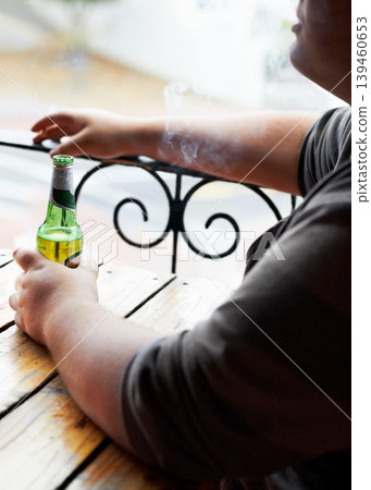 Outdoor, smoking and man with a beer, relax and weekend break at a restaurant, alcohol and pub. Person, outside and guy with cigarette, tobacco and drink with habit, bottle and peaceful with smoker Outdoor, smoking and man with a beer, relax and weekend break at a restaurant, alcohol and pub. Person, outside and guy with cigarette, tobacco and drink with habit, bottle and peaceful with smoker 139460653
