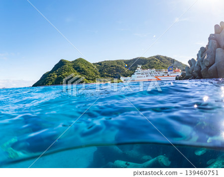 一張半淹沒在水下的阿卡島阿卡海灘照片。遠處有一艘渡輪駛過。阿卡海灘(真島濱),慶良間群島,島尻郡,沖繩縣 一張半淹沒在水下的阿卡島阿卡海灘照片。遠處有一艘渡輪駛過。阿卡海灘(真島濱),慶良間群島,島尻郡,沖繩縣 139460751