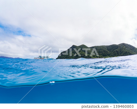 一張半淹沒在水下的阿卡島阿卡海灘照片。遠處有一艘渡輪駛過。阿卡海灘（真島濱），慶良間群島，島尻郡，沖繩縣 139460803