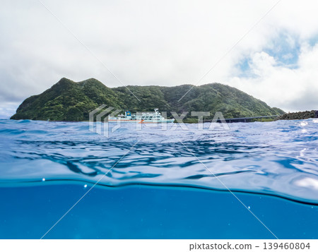 一張半淹沒在水下的阿卡島阿卡海灘照片。遠處有一艘渡輪駛過。阿卡海灘（真島濱），慶良間群島，島尻郡，沖繩縣 139460804