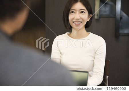A young woman talking to a man in the living room. A young woman talking to a man in the living room. 139460900
