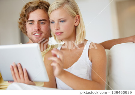 Smile, tablet and young couple on sofa browsing on social media or internet at apartment. Relax, digital technology and happy man and woman from Australia scroll on website in living room at home. 139460959