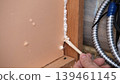 Applying thermal insulation foam with a gun. Using polyurethane foam along wall joints. Expanding the material. Sealing joints and soundproofing walls. Interior renovation. Close-up. Copy space. 139461145
