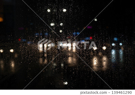 Rain on Window at Night with Blurred City Lights. Moody Urban Background. Raindrops Rain on Window at Night with Blurred City Lights. Moody Urban Background. Raindrops 139461290