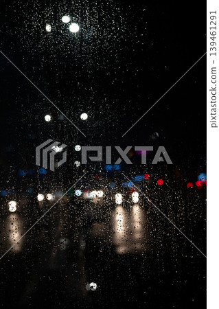 Rain on Window at Night with Blurred City Lights. Moody Urban Background. Raindrops Rain on Window at Night with Blurred City Lights. Moody Urban Background. Raindrops 139461291