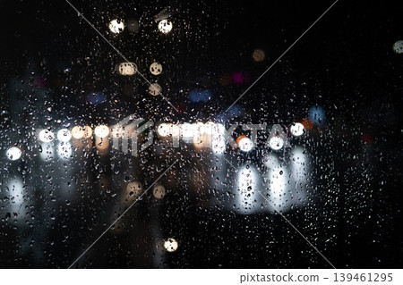 Rain on Window at Night with Blurred City Lights. Moody Urban Background. Raindrops Rain on Window at Night with Blurred City Lights. Moody Urban Background. Raindrops 139461295