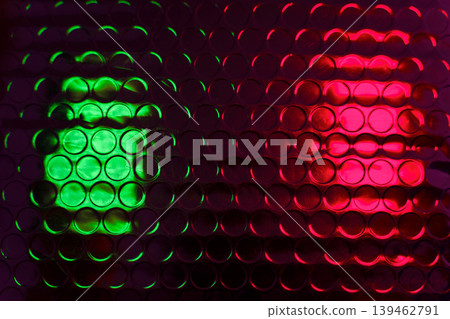 Glossy bubble wrap lit by green and red neon light creates an abstract textured pattern ideal for backgrounds, packaging design concepts, close-up texture studies and modern visual effects. Glossy bubble wrap lit by green and red neon light creates an abstract textured pattern ideal for backgrounds, packaging design concepts, close-up texture studies and modern visual effects. 139462791