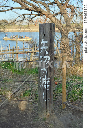 The Yagiri Ferry on the Edogawa River: A view of the traditional ferryboat and the river scenery through a wooden marker post. The Yagiri Ferry on the Edogawa River: A view of the traditional ferryboat and the river scenery through a wooden marker post. 139463121