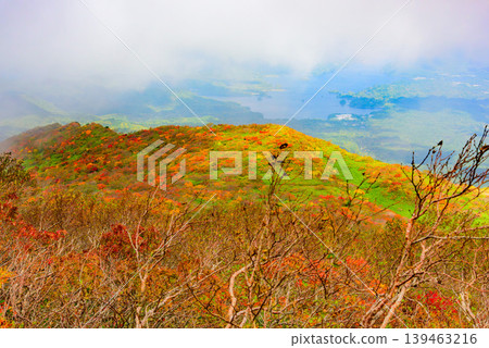 A sea of clouds and autumn foliage viewed from Mount Bandai: The contrast between the rising clouds and the autumn-colored mountain slopes. Fukushima Prefecture. A sea of clouds and autumn foliage viewed from Mount Bandai: The contrast between the rising clouds and the autumn-colored mountain slopes. Fukushima Prefecture. 139463216