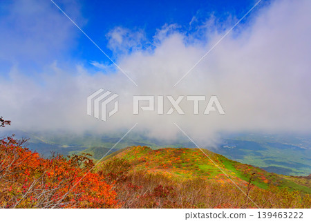 A sea of clouds and autumn foliage viewed from Mount Bandai: The contrast between the rising clouds and the autumn-colored mountain slopes. Fukushima Prefecture. A sea of clouds and autumn foliage viewed from Mount Bandai: The contrast between the rising clouds and the autumn-colored mountain slopes. Fukushima Prefecture. 139463222