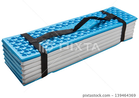 Compact folded hiking sleeping pad with black carrying strap for easy transport. Compact folded hiking sleeping pad with black carrying strap for easy transport. 139464369