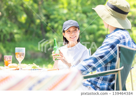 Men and women enjoying barbecue Men and women enjoying barbecue 139464384
