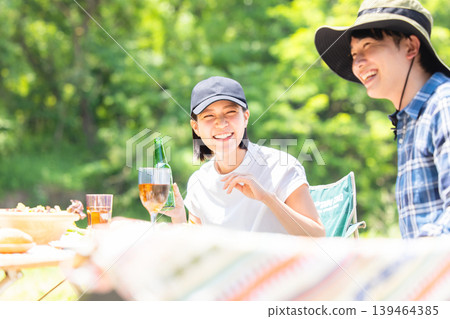 Men and women enjoying barbecue Men and women enjoying barbecue 139464385