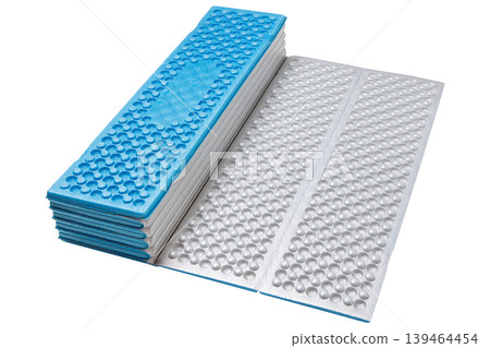 Partially unfolded outdoor foam mattress showing egg-carton texture for camping comfort. Partially unfolded outdoor foam mattress showing egg-carton texture for camping comfort. 139464454