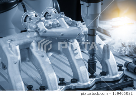 Close-up of automotive parts assembly process using a professional power wrench in a blue-toned industrial scene. Close-up of automotive parts assembly process using a professional power wrench in a blue-toned industrial scene. 139465081