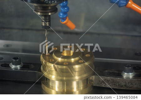 High-precision hole making process on brass material parts using a CNC milling machine and professional drill tool. High-precision hole making process on brass material parts using a CNC milling machine and professional drill tool. 139465084
