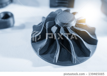 Innovative 3D printed turbocharger part prototype made by metal additive manufacturing in a blue-toned scene. 139465085