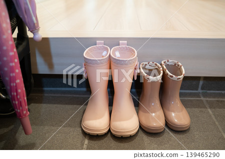 Rain boots and umbrella in the entryway 139465290