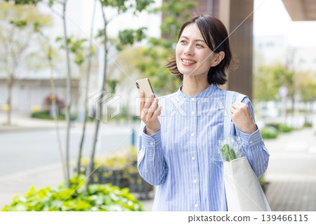 Middle women who operate smartphone outdoors 139466115