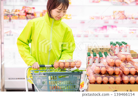A female staff member picks up an item that was ordered from the online supermarket. 139466154