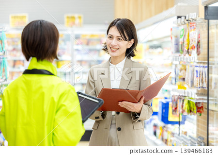 A woman working at a supermarket and a head office staff member A woman working at a supermarket and a head office staff member 139466183