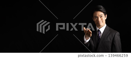 A man extending his right hand against a black background. A man extending his right hand against a black background. 139466259