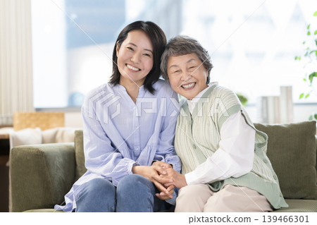 A portrait of a senior woman and a middle-aged woman, both smiling and looking at the camera, creating a mother-daughter image. A portrait of a senior woman and a middle-aged woman, both smiling and looking at the camera, creating a mother-daughter image. 139466301