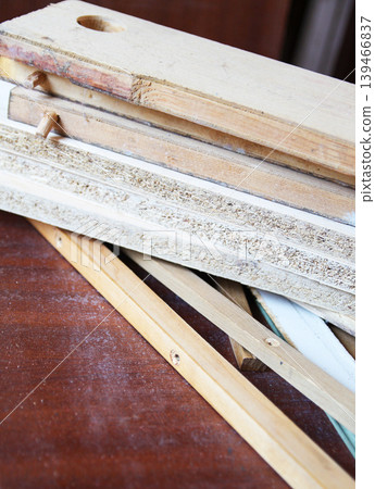 Detailed view of timber boards being repaired with visible surface imperfections and texture. Suitable for woodworking, renovation, and construction visuals. 139466837