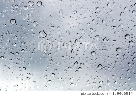 Close-up of glass pane with water droplets and blurred reflections behind it. Suitable for weather themes, emotional storytelling, and modern graphic design. Close-up of glass pane with water droplets and blurred reflections behind it. Suitable for weather themes, emotional storytelling, and modern graphic design. 139466914