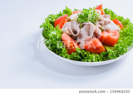 Pork shabu-shabu salad, a refreshing cold shabu-shabu salad with lettuce and tomatoes, white background. 139468293