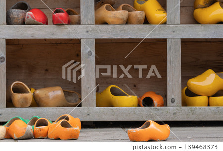 Old Colorful Wooden Clogs on Pavement Near Shelf Old Colorful Wooden Clogs on Pavement Near Shelf 139468373