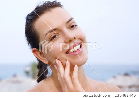 Beauty woman touching smooth facial complexion with radiant healthy glowing appearance outdoors naturally. Beautiful female applying sun cream and showing fresh skincare texture during daily beauty Beauty woman touching smooth facial complexion with radiant healthy glowing appearance outdoors naturally. Beautiful female applying sun cream and showing fresh skincare texture during daily beauty 139468449