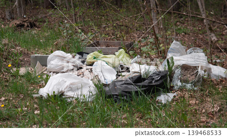 New Green Shoots Surrounding Dumped Bags, Contrast Between Fresh Seedlings And Plastic Waste, Hopeful Regeneration Threatened By Pollution, Scene Calls For Community Restoration And Cleanup Action 139468533