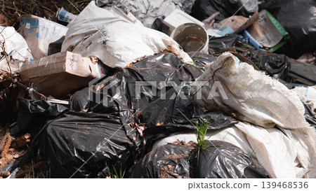 Torn Black Bags Revealing Mixed Waste, Spilled Packaging And Organic Matter, Strong Odor And Vermin Signs, Closeup Highlighting Public Health Risk And Need For Rapid Sanitation Response Torn Black Bags Revealing Mixed Waste, Spilled Packaging And Organic Matter, Strong Odor And Vermin Signs, Closeup Highlighting Public Health Risk And Need For Rapid Sanitation Response 139468536