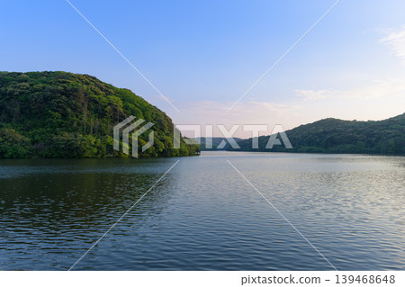 A tranquil lakeside landscape adorned with vibrant new greenery and the scenery of early summer. A tranquil lakeside landscape adorned with vibrant new greenery and the scenery of early summer. 139468648