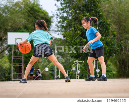 Active students practicing basketball drills during physical education class or after school sports program. Active students practicing basketball drills during physical education class or after school sports program. 139469235
